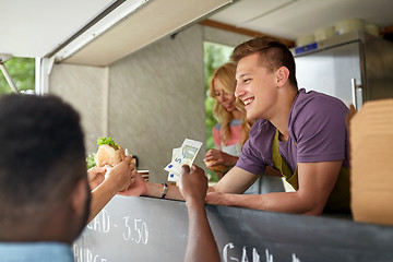 Image showing happy salesman selling hamburgers at food truck