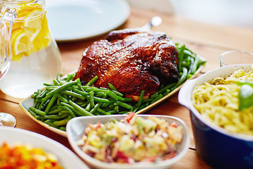 Image showing roast chicken with garnish of green beans on table