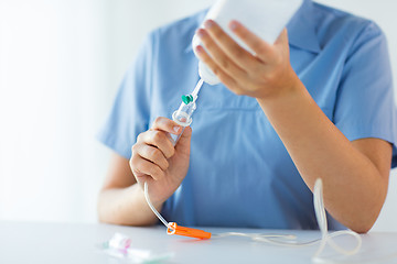 Image showing close up of nurse preparing drop counter