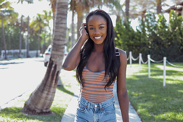 Image showing Smiling black woman adjusting hair