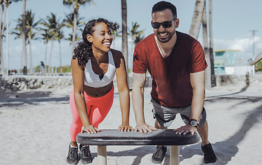 Image showing Laughing sportive couple training in beach gym 