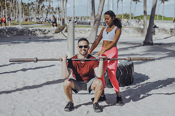 Image showing Woman helping man with workout on beach