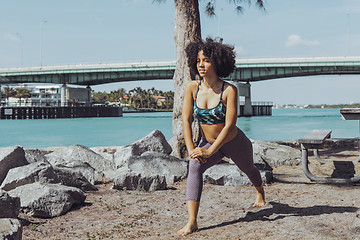 Image showing Black sportive girl warming up in park