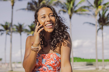 Image showing Pretty ethnic woman talking on smartphone in summertime