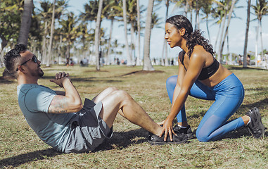 Image showing Woman helping man with exercise in park