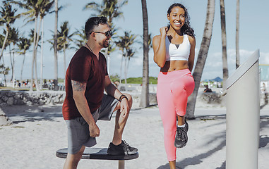 Image showing Cheerful girl training with instructor on beach