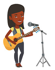 Image showing Woman singing in microphone and playing guitar.