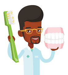 Image showing Dentist with dental jaw model and toothbrush.