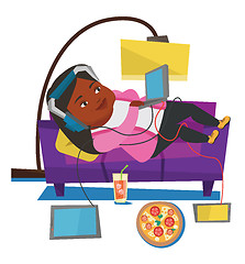 Image showing Woman lying on sofa with many gadgets.