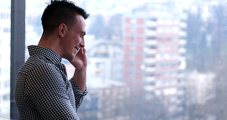 Image showing Business Man Talking On Cell Phone, Looking Out Office Window