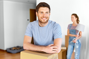 Image showing happy couple with boxes moving to new home