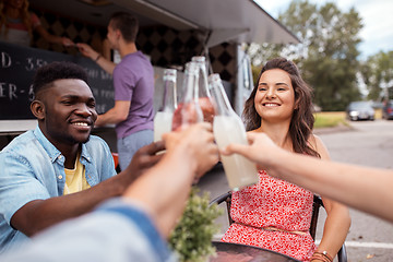 Image showing friends clinking bottles with drinks at food truck