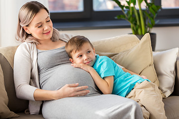 Image showing happy pregnant mother and son hugging at home