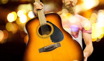 Image showing close up of musician with guitar over night lights