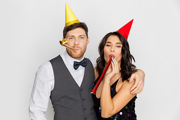 Image showing happy couple with party blowers having fun