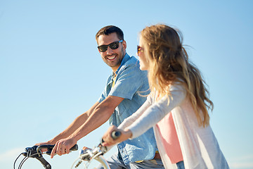 Image showing happy young couple riding bicycles in summer