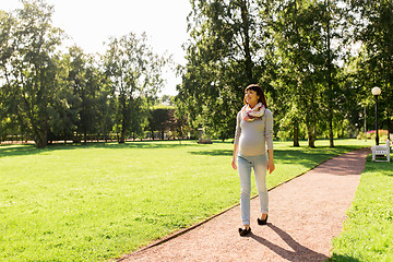 Image showing happy pregnant asian woman walking at park