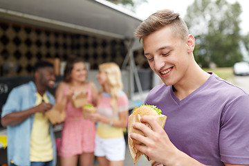 Image showing happy man with hamburger and friends at food truck