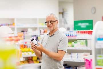 Image showing senior male customer with drug at pharmacy