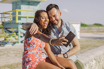 Image showing Excited couple taking selfie on seafront