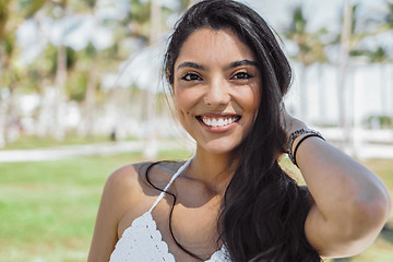 Image showing Content bright girl touching hair in sunshine