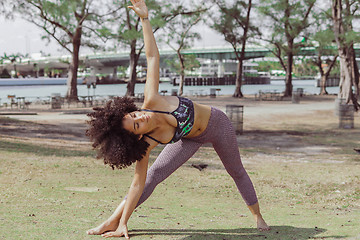 Image showing Black sportive girl training asana on lawn