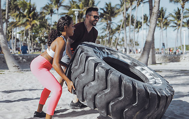 Image showing Sportive couple training with tyre together