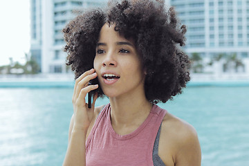 Image showing Black girl having phone call on seafront