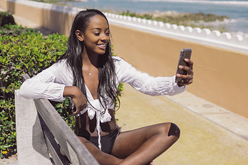 Image showing Woman taking selfie on bench