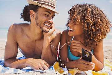 Image showing Couple on beach listening to music and smiling