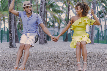 Image showing Couple holding hands on swing