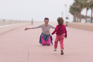 Image showing mother and cute little girl on the promenade by the sea