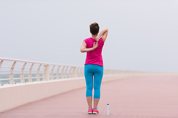 Image showing woman stretching and warming up on the promenade