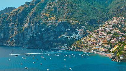 Image showing One of the best resorts of Italy with old colorful villas on the steep slope, nice beach, numerous yachts and boats in harbor and medieval towers along the coast, Positano.