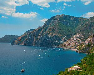 Image showing One of the best resorts of Italy with old colorful villas on the steep slope, nice beach, numerous yachts and boats in harbor and medieval towers along the coast, Positano.