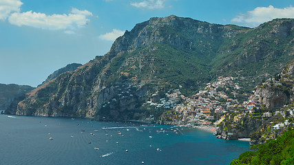 Image showing One of the best resorts of Italy with old colorful villas on the steep slope, nice beach, numerous yachts and boats in harbor and medieval towers along the coast, Positano.