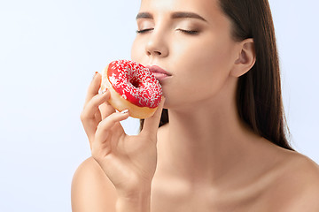 Image showing beautiful woman biting a donut