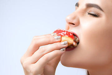 Image showing beautiful woman biting a donut