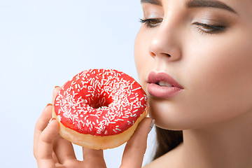 Image showing beautiful woman biting a donut