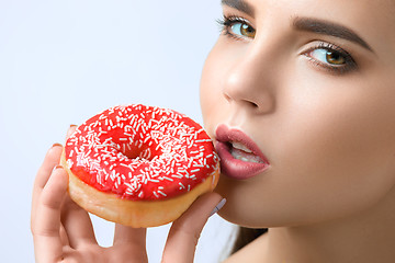 Image showing beautiful woman biting a donut