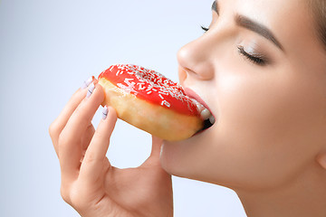 Image showing beautiful woman biting a donut