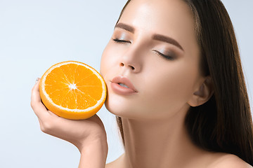 Image showing Beautiful woman\'s face with juicy orange