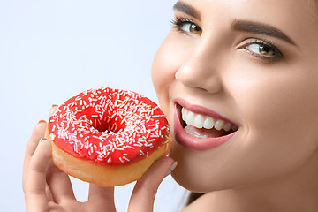 Image showing beautiful woman biting a donut