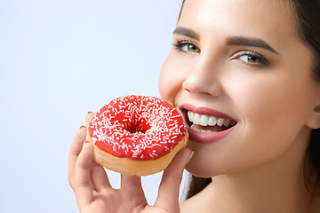 Image showing beautiful woman biting a donut