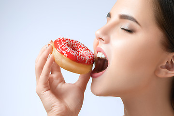 Image showing beautiful woman biting a donut