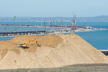 Image showing Taman, Russia - 15 April 2017: A huge pile of soil in the foreground, and the bend of the bridge under construction across the Kerch Strait in the background, as of April 2017