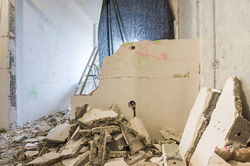 Image showing Dismantling of partitions in the apartment, around a heap of broken parts of the wall