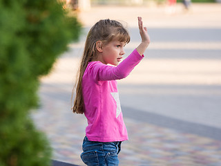 Image showing Six-year-old girl waving his hand, side view