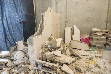 Image showing Broken parts of the wall lie around the wall being dismantled