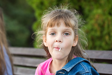 Image showing Portrait of a six-year-old gay girl who sucks a lollipop